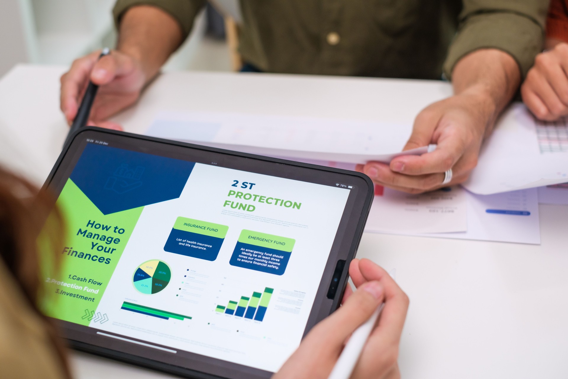 asian financial advisor presenting charts and data on a tablet during couple client meeting.financial planning and decision-making