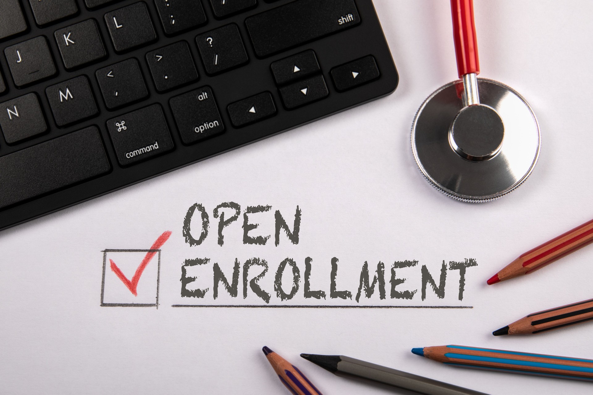 Open Enrollment. Registration and Research concept. Stethoscope and black computer keyboard on a white table